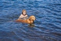 Happy kid playing with dog on beach. Little boy playing with dog in water. Royalty Free Stock Photo