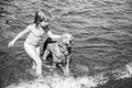 Happy kid playing with dog on beach. Little boy playing with dog in water. Royalty Free Stock Photo