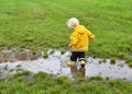 Toddler boy playing in a muddy puddle after the rain Royalty Free Stock Photo