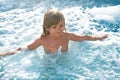 Happy kid playing in outdoor swimming pool on hot summer day. Kids learn to swim. Child in water. Children play in Royalty Free Stock Photo