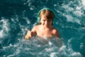 Happy kid playing in outdoor swimming pool on hot summer day. Kids learn to swim. Child in water. Children play in Royalty Free Stock Photo