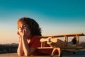 Happy kid playing with toy airplane against blue sky background. Cute child 8 year old on a sunny summer day. Kids Royalty Free Stock Photo