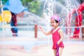 Happy kid playing in water fountain at water park. Children play with water in summer or spring. Royalty Free Stock Photo