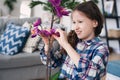 Happy kid posing with orchid flower at home. Moving to new apartment