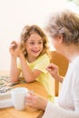 Happy kid putting puzzles together with his grandmother