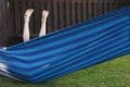 Happy kid relaxing in a hammock outdoor. feet of a child barefoot. Holidays vacation