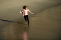 Happy kid running on sea beach. Funny boy run along surf edge. Active kids lifestyle. Little runner exercising. Sporty Royalty Free Stock Photo