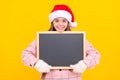 happy kid in santa claus hat hold blackboard for copy space. teen girl in mittens