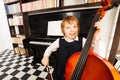 Happy kid in school dress playing on the cello Royalty Free Stock Photo