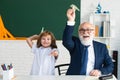 Happy kid in school. Old senior teacher and pupil hold paper airplane. Education, teachering, elementary school. Royalty Free Stock Photo