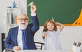 Happy kid in school. Old senior teacher and pupil hold paper airplane. Education, teachering, elementary school. Royalty Free Stock Photo