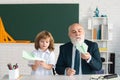 Happy kid in school. Teacher help to learn pupil. Education, teachering, elementary school. Royalty Free Stock Photo