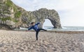 Happy kid smiling face balancing on one leg with raising hands on the sand, Child staning one leg on pebbles in sunny day summer