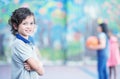 Happy kid smiling in schoolyard with other chilldren playing on