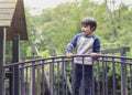 Happy kid standing on bridge on tree house in playground Active child wearing jumper playing outdoor in forest park, Portrair Royalty Free Stock Photo