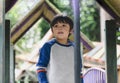 Happy kid standing on tree house in playground, Active child wearing jumper playing outdoor in forest park, Portrair little boy Royalty Free Stock Photo