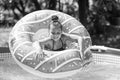 Happy kid swim in donut pool float in swimming pool on sunny summer day, floatation