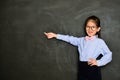 Happy kid tutor using chalk pointing empty area Royalty Free Stock Photo