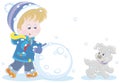 Cheerful little boy making a big snowball