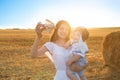 Happy kid and woman playing with toy airplane against field. Royalty Free Stock Photo