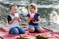 Happy kids with apple juice having fun on the beach Royalty Free Stock Photo