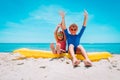 Happy cute boy and girl with floatie on beach vacation Royalty Free Stock Photo