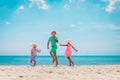 Happy kids- boy and girls- dance at beach, family enjoy vacation at sea Royalty Free Stock Photo