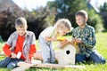 Happy kids boys brothers tinkering outdoors at sunny day