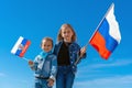 Happy kids, cute girls with Russia flag against a clear blue sky