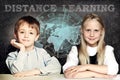 Happy kids and distance learning. Smart school girl and boy on blackboard background with world map Royalty Free Stock Photo