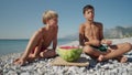 Happy kids eating big red slices of watermelon on the beach