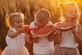 Happy kids eating watermelon. Kids eat fruit outdoors. Healthy snack for children. Little girls and boy playing in the garden Royalty Free Stock Photo