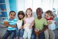 Happy kids enjoying popcorn and drinks while sitting Royalty Free Stock Photo