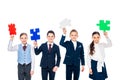 Happy kids in formal wear holding puzzle pieces Isolated On White. Royalty Free Stock Photo