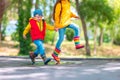 Happy kids girl and boy with umbrella and colorful rubber rain boots playing outdoor and jumping in rainy puddle Royalty Free Stock Photo