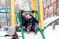 Happy kids having fun on playground at winter. Winter leisure outdoor activities. Mother with two son on a winter walk Royalty Free Stock Photo