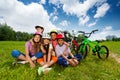 Happy kids in helmets sit on grass and hug Royalty Free Stock Photo