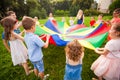 Happy kids holding parachute during funny game