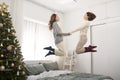 Happy kids jumping, having fun, playing on bed in bedroom enjoying of morning Royalty Free Stock Photo