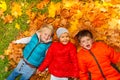 Happy kids laying together on the autumn leaves