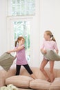 Happy kids, pillow fight and girls playing on sofa in living room together for fun bonding at home. Couch, siblings or Royalty Free Stock Photo