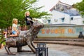 Happy kids play on funny metal cat statue