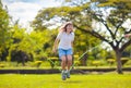 Happy kids play outdoor. Children skipping rope Royalty Free Stock Photo