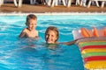 Happy kids playing in blue water of swimming pool. Royalty Free Stock Photo