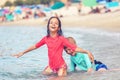 Happy kids playing in water at beach during summer vacation Royalty Free Stock Photo