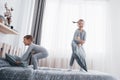 Happy kids playing in white bedroom. Little boy and girl, brother and sister play on the bed wearing pajamas. Nightwear Royalty Free Stock Photo