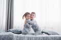 Happy kids playing in white bedroom. Little boy and girl, brother and sister play on the bed wearing pajamas. Nursery Royalty Free Stock Photo