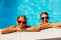 Happy kids in the pool, Funny kids in sunglasses playing outdoors, little boy and girl swim in the pool on a summer sunny day Royalty Free Stock Photo