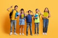 Happy kids pupils with backpacks and notebooks in their hands Royalty Free Stock Photo