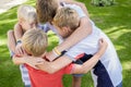 Happy kids representing youth and fun. Team work. Children in a group hug outside. Close up